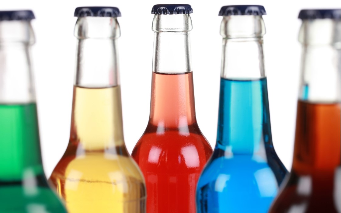 Das Bild zeigt mehrere Glasflaschen die mit verschiedenfarbigen Flüssigkeiten gefüllt sind